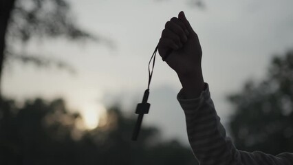 Little girl holding cross and praying, silhouette light.