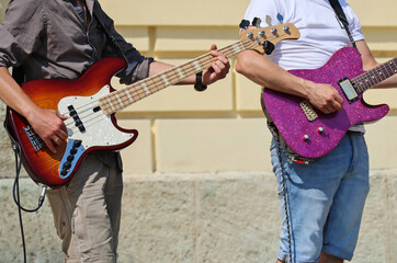 Men are playing electric guitars on the street