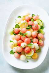 Summer salad of watermelon and melon in the form of balls with fresh mint and jalapeno pepper, close up.