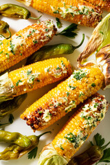Grilled corn cobs with butter and herbs, close up.