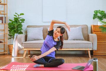 Young Asian healthy woman exercising with laptop at home