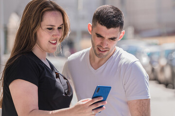 couple looking at mobile phone in the street