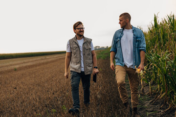 Front view of two agronomists walking in the fields.