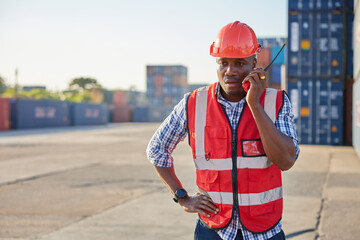 African factory worker or engineer using walkie talkie and talking about work in containers warehouse storage