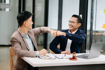 Man lawyer hand and Man client shaking hand collaborate on working agreements with contract documents at the office..