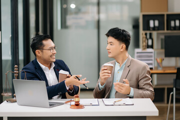 Two Asian businessman and man discuss investment project working and planning strategy with tablet laptop computer in modern office..