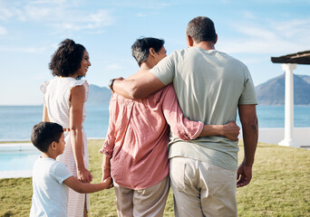 Back, summer and vacation by the sea with family outdoor together looking at a view of nature. Grandparents, mother and happy son by the ocean for love, holiday freedom or weekend getaway and travel