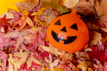 Photo of a Halloween pumpkin on a background of red autumn leaves