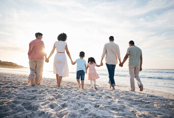 Walking, holding hands and back of big family at the beach for travel, vacation and adventure in nature. Love, freedom and rear view of children with parents and grandparent at sea for ocean journey