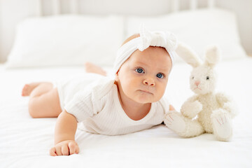 smiling baby girl with blue eyes close-up portrait, happy little baby of six months lying on her...