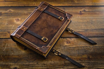 Aged Leather Book Cover with Closure Belts - Displayed on Wooden Table with Opened Belts