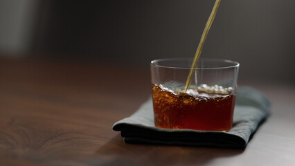 pour nitro coffe in tumbler glass on wood table