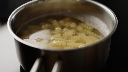 close up photo boiling pasta in saucepan