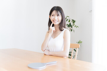 Obraz na płótnie Canvas 歯に指をおさえる日本人女性