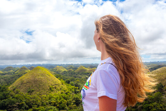Young woman standing on top of the mountain enjoying view on Chocolate Hills