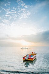 A wooden colorful traditional boat floating on the beach in the morning. Selective focus.