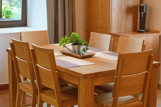 Solid wood kitchen furniture. Table and chairs, cozy home interior.