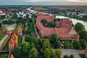 The Castle of the Teutonic Order in Malbork by the Nogat river at sunset. Poland