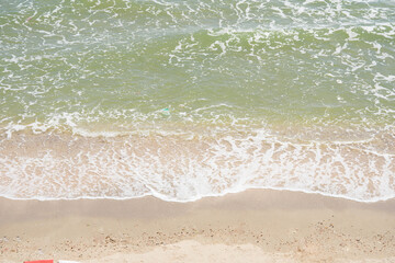 Aerial view of sea waves, sandy beach.