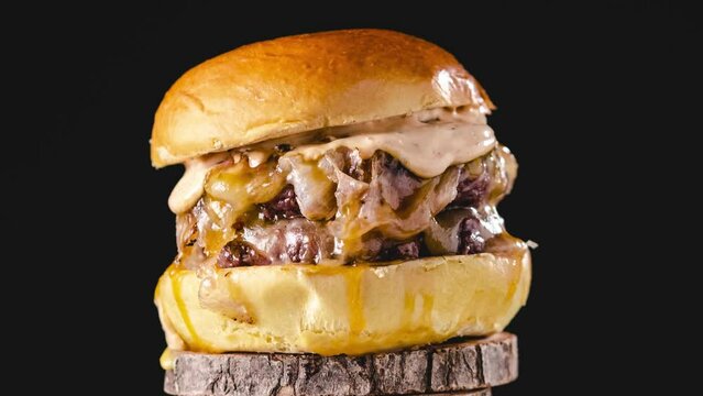 Delicious burger rotating on wooden stand. stop motion