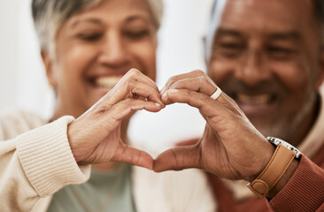 Heart, hands and happy senior couple with love, thank you sign or healthy gesture in their home together. Care, shape and old people show emoji frame in support of marriage, trust or retirement