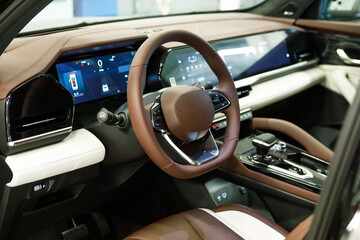 empty interior of modern premium car with three touch displays. white and brown interior, driver's...