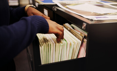 File cabinet, legal documents and person hands with management of tax report at office. Accountant,...