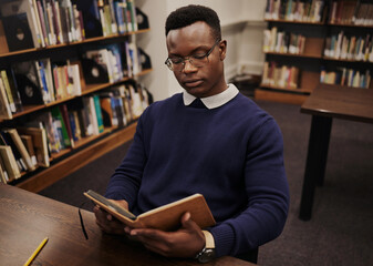 University, book and black man student reading and learning in a college for knowledge development....