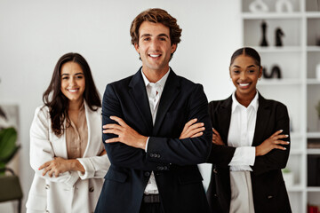Successful european businessman standing in front of business team posing in office interior, smiling to camera