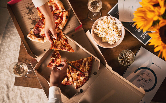 Food, pizza and hands, business meeting and wine with paperwork, people in team and dinner with top view. Popcorn, Italian cuisine meal and snack, eating and documents, collaboration and working