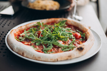 Fresh pizza with tomato, arugula and cheese on a dark table. Food banner
