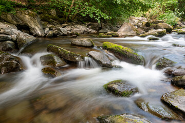 Naklejka na ściany i meble Long exposure of a waterfall on the East Lyn river at Watersmeet in Exmoor National Park