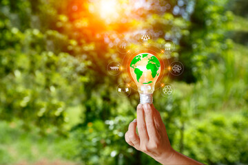 Green Energy Renewable Sustainable. world and green energy icon in light bulb on green nature...
