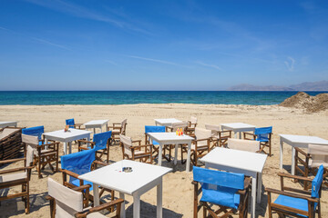 Fototapeta na wymiar Tables and chairs on the beach in the resort town of Mastichari on the island of Kos. Greece