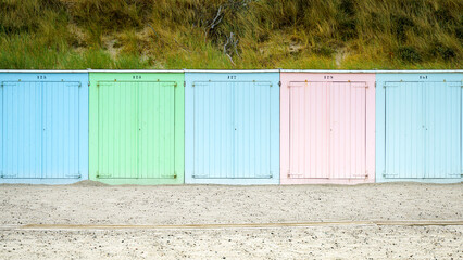 Row of small striped colorful  beach huts