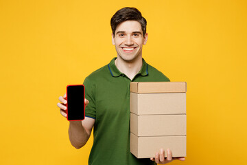Young man he wears green t-shirt casual clothes hold stack cardboard blank boxes use mobile cell...