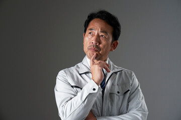 考えるミドルエイジの作業員　黒背景