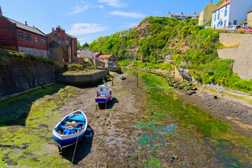 Three fishing boats sitting on the bed of Staithes Beck in Staithes.
