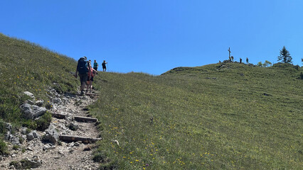 Bergwanderer von hinten auf einem Pfad unterwegs zum Gipfelkreuz der Rampoldplatte,...