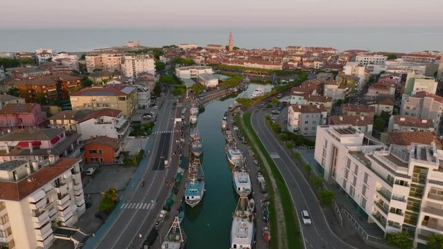 Aerial shot of a Caorle, the Resort sea beach city near to Venice. Fisherman boats in lagoon at sunset time