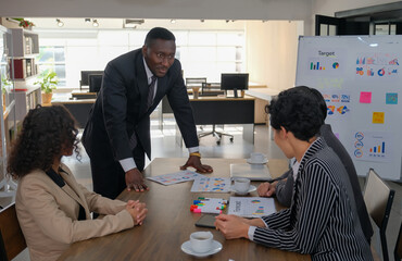 Confident African businessman discussing business ideas with colleagues at meetings to make the target of the project