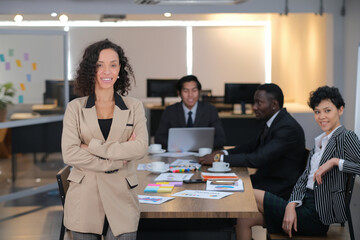 Portrait of a confident business woman with all ethnicity business team in the background