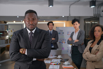 Black african businessman with crossed arms with his teams