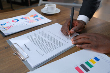 The hand of a black businessman signing a contract