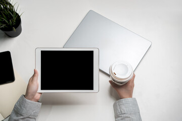 Holding coffee and black screen touch pad screen for mockup multimedia technology device with...