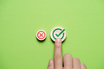 Hand select and touching to green correct sign mark between Red Cross mark which print screen on...