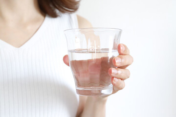 コップに入った水を持った女性