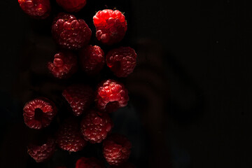 ripe red raspberries on a dark background