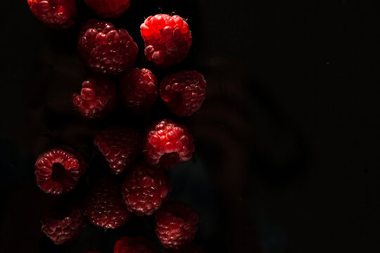 ripe red raspberries on a dark background