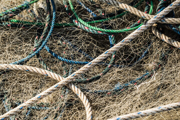 Piles of fishermen fishing nets after being used to catch fish in the sea laid on shore during sunny day with white sand backgrounds at Ngrenehan Beach, Gunungkidul, Jogja